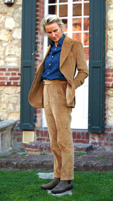 Fanny devant une maison à Trouville porte le costume droit unisexe Wes en velours côtelé couleur noisette de la collection Automne Hiver 2024 de la Maison Gabriel Paris