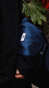 Pablo Saavedra de Decker aux Puces de Saint Ouen porte le manteau droit Hannibal en laine et cachemire bleu marine - détail intérieur - de la Maison Gabriel Paris