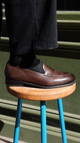 Victor porte le mocassin Newport, en cuir lisse coloris marron ébène, collaboration Malfroid x Gabriel, vue de côté, de la Maison Gabriel Paris