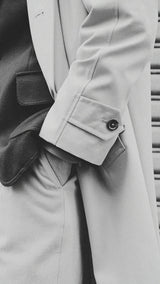 Pablo Saavedra de Decker aux Puces de Saint Ouen porte le manteau raglan Hadrien en coton coloris mastic de la Maison Gabriel Paris - détail de la manche