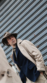 Pablo Saavedra de Decker aux Puces de Saint Ouen porte le manteau raglan Hadrien en coton coloris mastic de la Maison Gabriel Paris