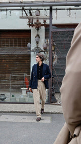 Pablo Saavedra de Decker est aux Puces de Saint Ouen et porte le blazer croisé Edgar en laine nattée bleu marine de la Maison Gabriel Paris