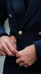 Pablo Saavedra de Decker est aux Puces de Saint Ouen et porte le blazer croisé Edgar en laine nattée bleu marine de la Maison Gabriel Paris - photo de détail du blazer