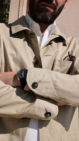 Élie les bras croisés, porte la veste de peintre Éliézer en coton vert sauge - Collection Printemps été 2025 - Maison Gabriel Paris