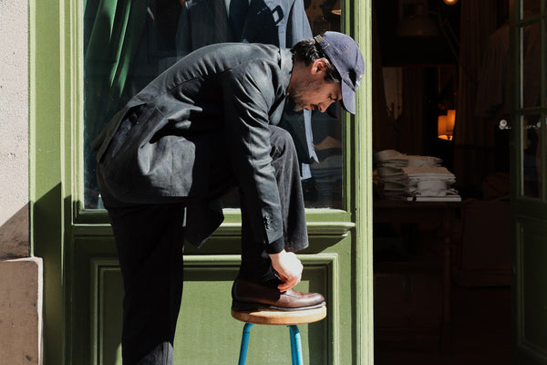 Victor Bastié devant la boutique Maison Gabriel Paris porte le mocassin Newport, en cuir lisse coloris marron ébène, collaboration Malfroid x Gabriel