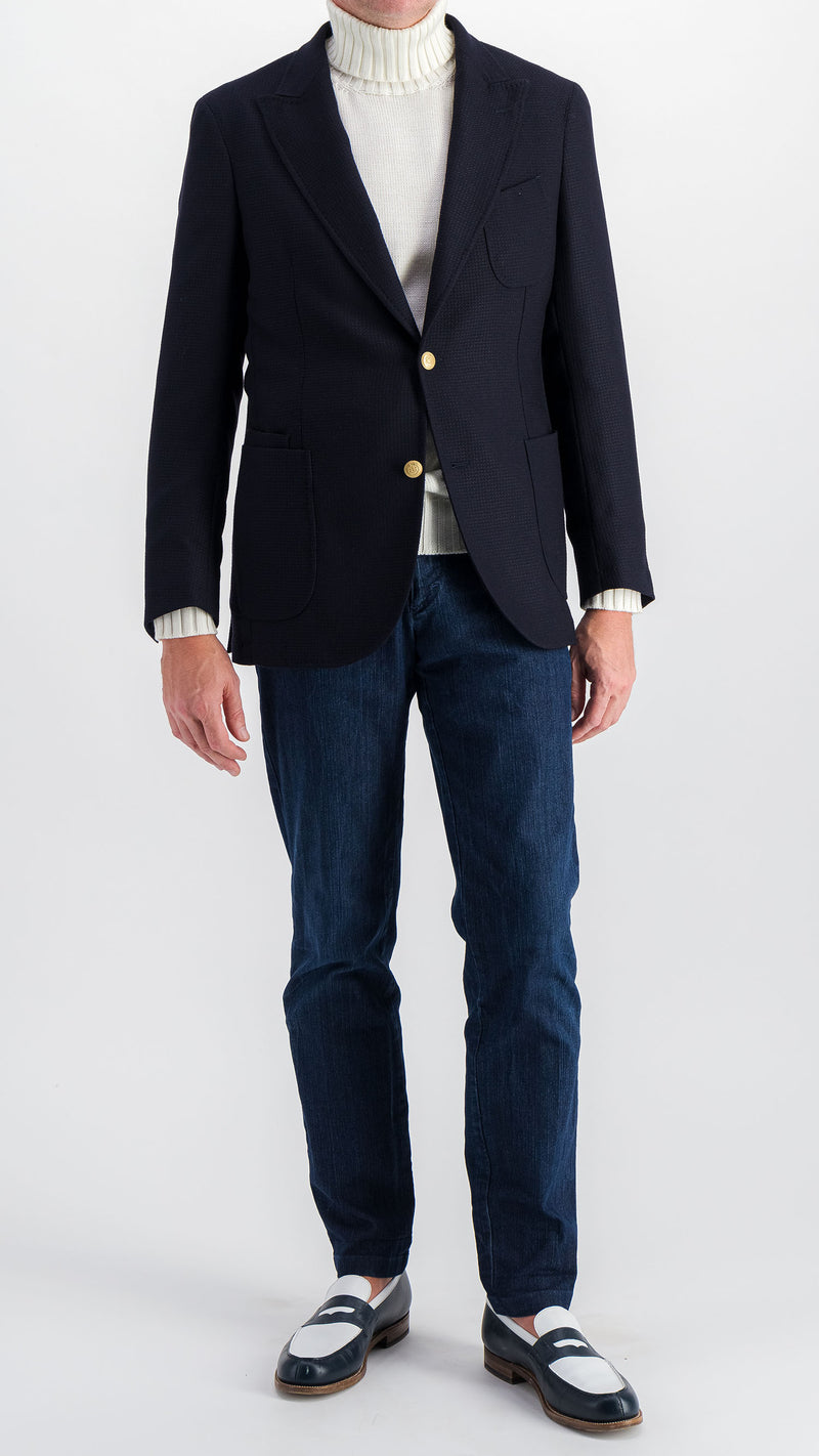 Le mannequin studio porte le blazer Ripley en laine natté bleu marine et le pull Philippe col roulé en laine mérinos blanc de la collection Plein Soleil et le jean Arthur, vue de face, de la Maison Gabriel Paris