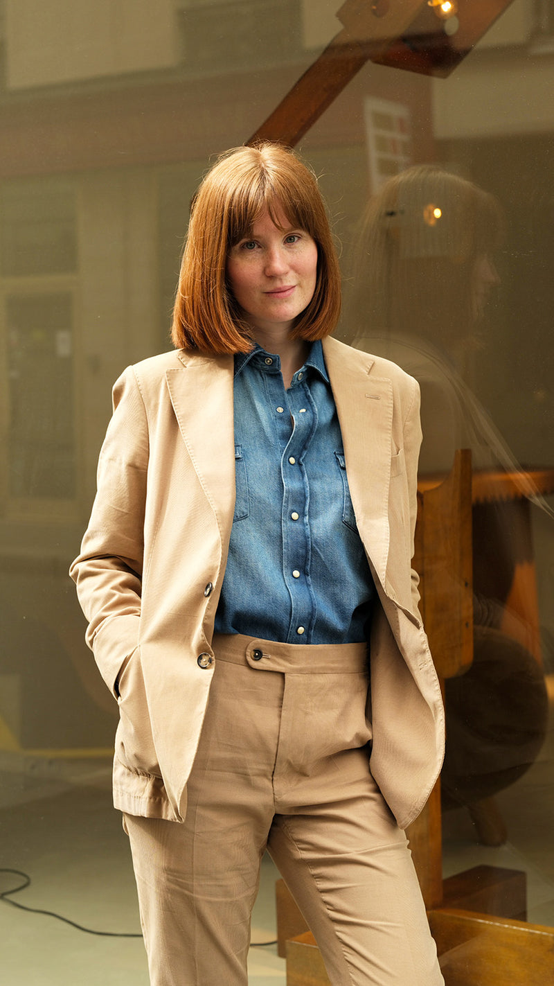 Clémentine pose devant la Galerie Aurélien Serre et porte le costume Charly en milleraies d'été beige de la Maison Gabriel Paris - UNISEXE