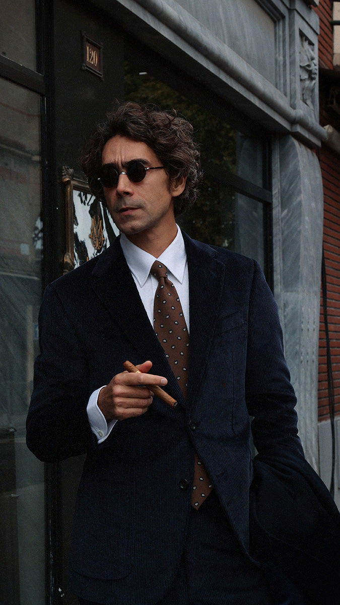 Pablo Saavedra de Decker aux Puces de Saint Ouen porte le costume droit Maximilien en velours côtelé bleu nuit de la Maison Gabriel Paris