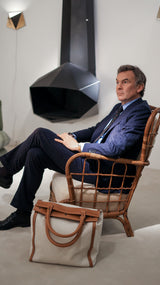 Cyril assis porte le costume droit Gabriel en flanelle bleu marine à rayures craies, nouvelle édition de la collection Iconique de la Maison Gabriel Paris 
