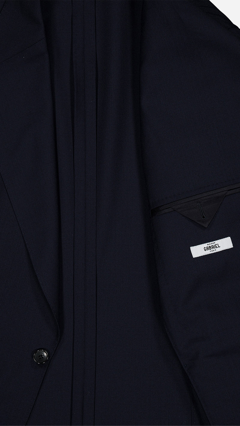 Détail tissu de la veste du costume droit Stéphane en fresco bleu nuit, photographiée à plat vue intérieure de la Maison Gabriel Paris