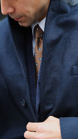Pablo Saavedra de Decker aux Puces de Saint Ouen porte le manteau droit Hannibal en laine et cachemire bleu marine - détail du col - de la Maison Gabriel Paris