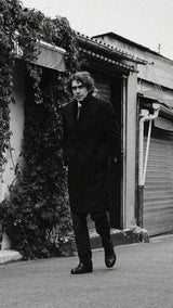 Pablo Saavedra de Decker aux Puces de Saint Ouen porte le manteau droit Hannibal en laine et cachemire bleu marine de la Maison Gabriel Paris