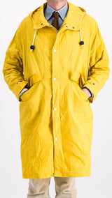 Le mannequin studio porte le manteau de pluie Jean-Louis en wax jaune - 3/4 vue de face - de la Maison Gabriel Paris