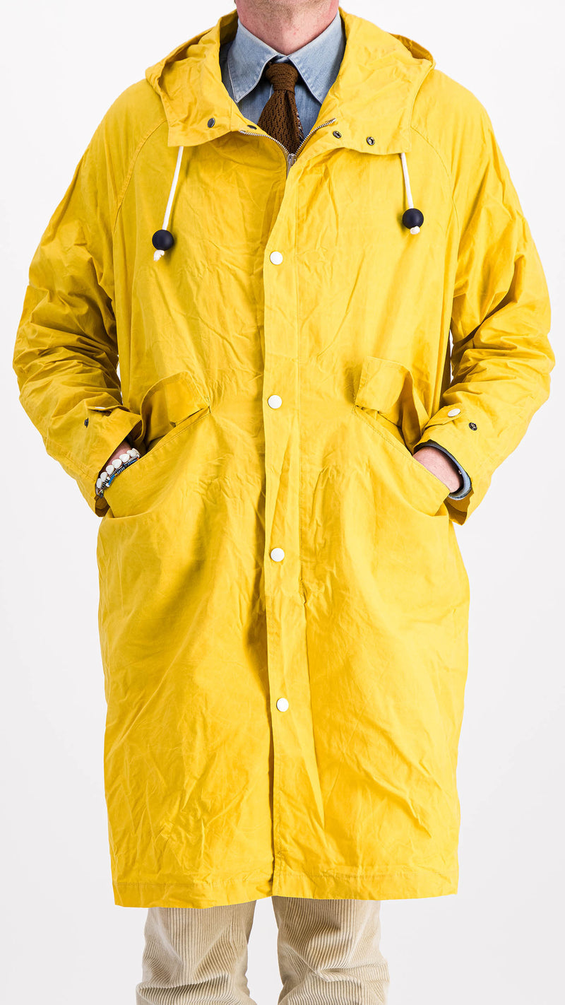Le mannequin studio porte le manteau de pluie Jean-Louis en wax jaune - 3/4 vue de face - de la Maison Gabriel Paris