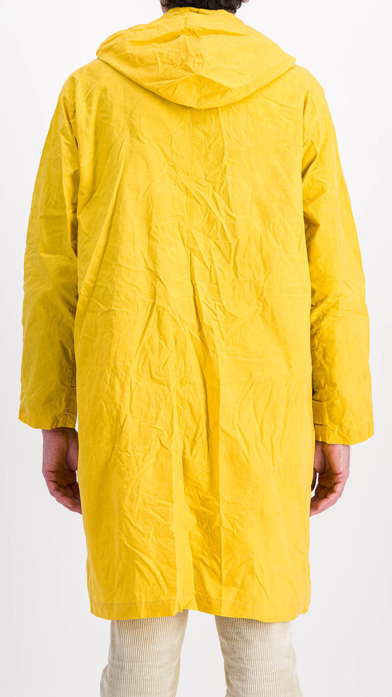 Le mannequin studio porte le manteau de pluie Jean-Louis en wax jaune - 3/4 vue de dos - de la Maison Gabriel Paris