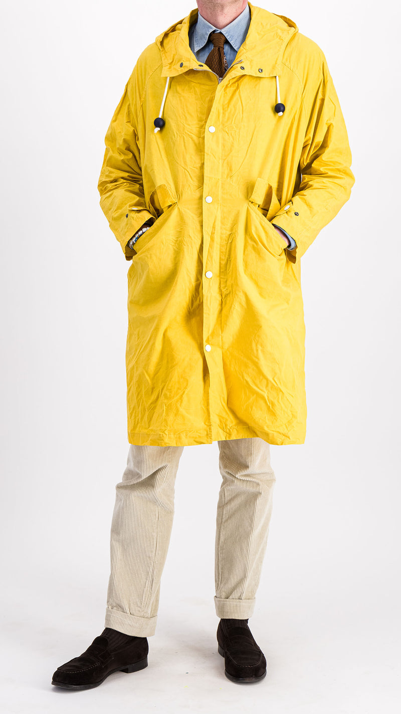 Le mannequin studio porte le manteau de pluie Jean-Louis en wax jaune - vue de face - de la Maison Gabriel Paris