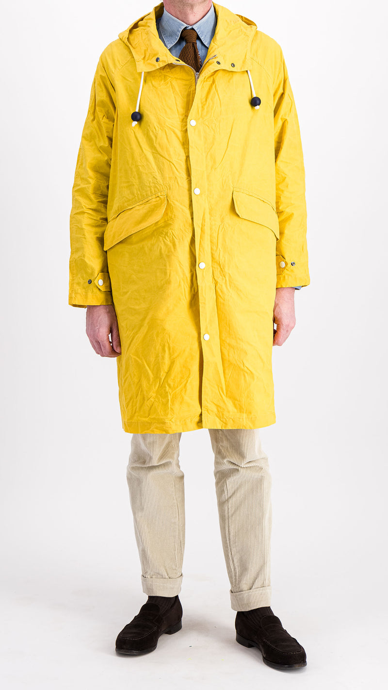 Le mannequin studio porte le manteau de pluie Jean-Louis en wax jaune - vue de face - de la Maison Gabriel Paris