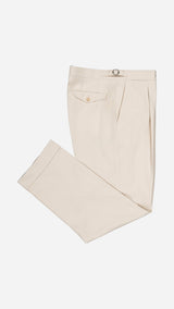 Le pantalon chino Leo en coton japonais  coloris beige - photographié plié vue de haut - Collection Printemps Été 2026  - Maison Gabriel Paris.