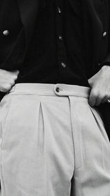 Pablo Saavedra de Decker aux Puces de Saint Ouen porte le pantalon chino Léo coloris mastic en coton japonais de la  Collection A/H 2025 - détails du pantalon - Maison Gabriel Paris