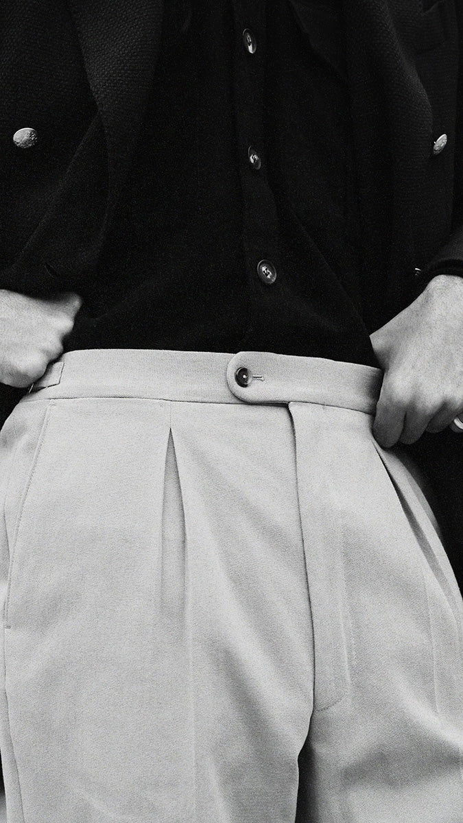 Pablo Saavedra de Decker aux Puces de Saint Ouen porte le pantalon chino Léo coloris mastic en coton japonais de la  Collection A/H 2025 - détails du pantalon - Maison Gabriel Paris