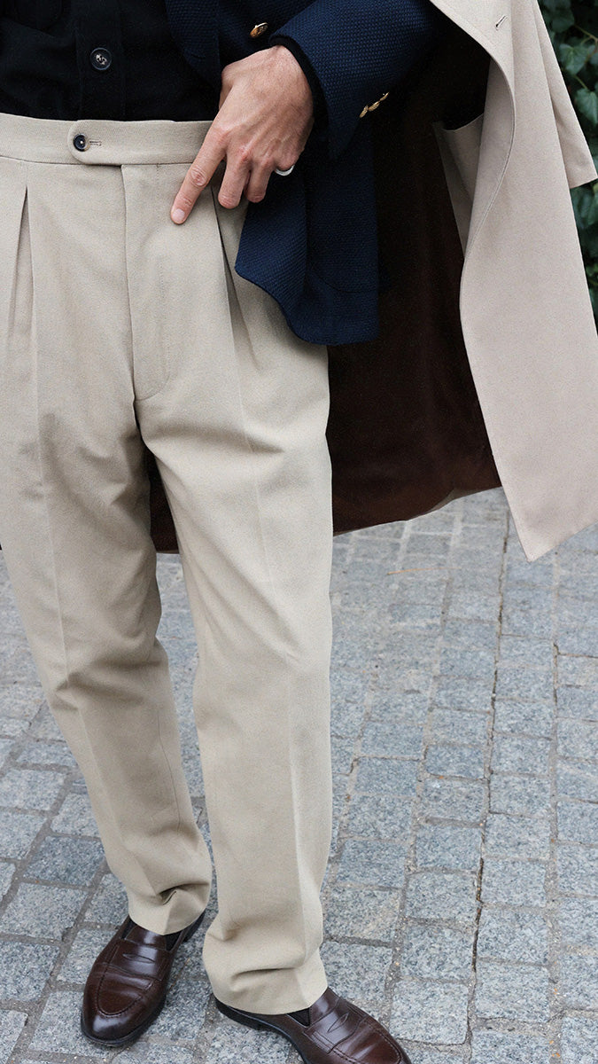 Pablo Saavedra de Decker aux Puces de Saint Ouen porte le pantalon chino Léo coloris mastic en coton japonais de la  Collection A/H 2025 - détails du pantalon - Maison Gabriel Paris
