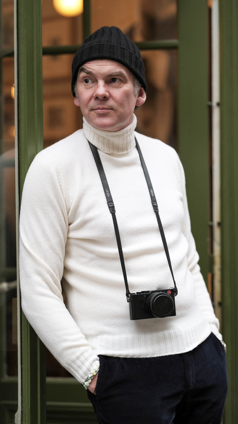 Cyril devant la boutique porte le pull Basile en laine et cachemire blanc col roulé de la Maison Gabriel Paris