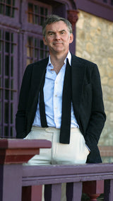 Cyril à Trouville porte de façon décontractée la veste droite Albert en en bouclette de laine noire de la collection Automne Hiver 2024 Maison Gabriel Paris