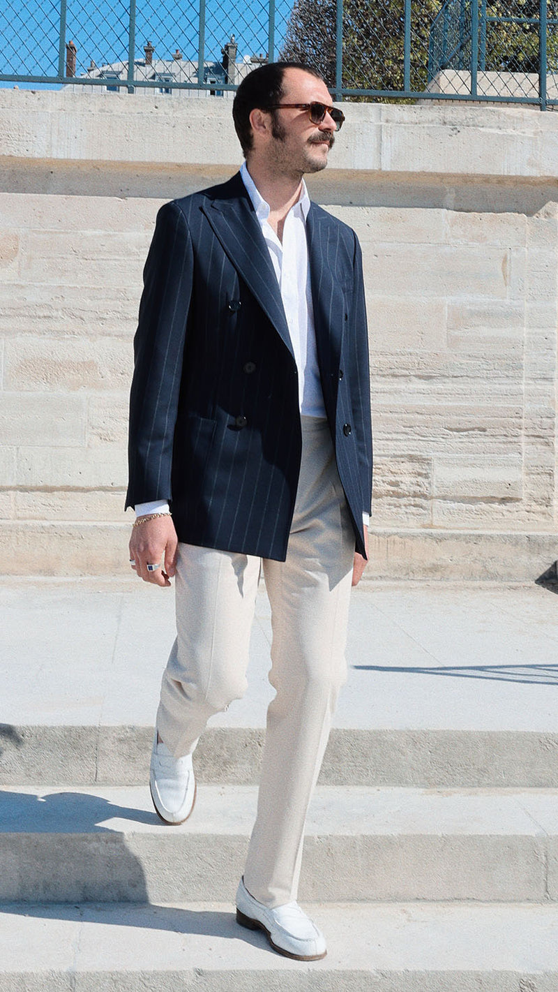 Titouan aux Tuileries porte la veste croisée Serge en fresco bleu à rayures tennis - Collection Printemps été 2025 - Maison Gabriel Paris